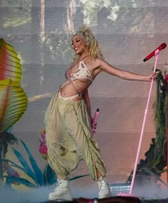 a woman is performing on stage with her arms outstretched