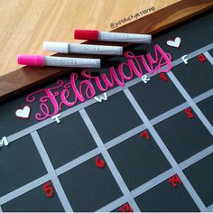 three markers that are on top of a chalkboard with the word february written in it