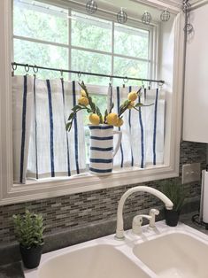 a white sink sitting under a window next to a faucet