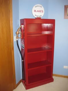 a red bookcase in the corner of a room