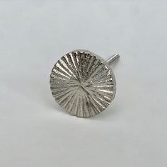 a close up of a small silver object on a white surface with no people around it