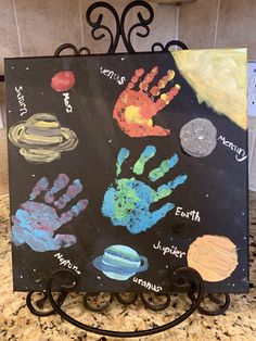 a black board with handprints on it in front of a marble counter top