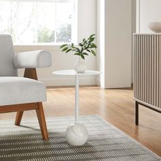 a living room with a chair, table and potted plant on the floor next to a radiator