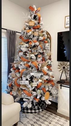 a decorated christmas tree in the corner of a living room with black and white decor