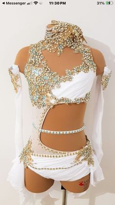 a white and gold belly dance costume on display