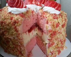 a cake with strawberries and cream on top is cut into slices to show the layers