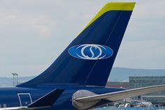 two blue and yellow airplanes parked at an airport