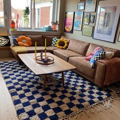 a living room filled with furniture and lots of pictures on the wall behind the couch