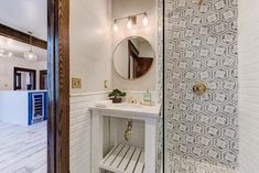 a bathroom with a sink, mirror and stand up shower