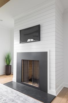 a flat screen tv mounted on the wall above a fireplace