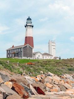 a light house on top of a hill next to rocks