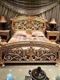 an ornate gold bed in a bedroom with two lamps on either side of the bed