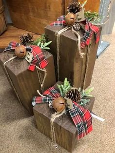 three wrapped presents with pine cones and plaid bows