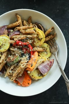 a white bowl filled with pasta and vegetables