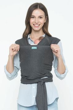 a woman is holding up her baby carrier