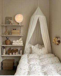 a bed with a white canopy over it in a bedroom next to a wall shelf