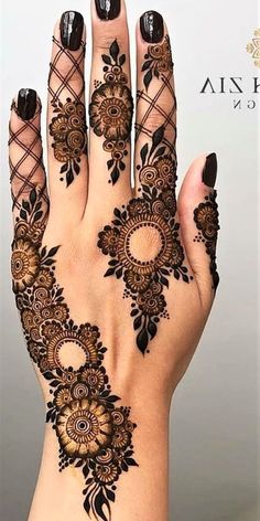 a woman's hand with henna tattoos on it