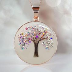 Beautiful handmade item! Here, on Etsy made as simulation only-just resin and white color.  If you need to send the hair to us, please send the hair right after the purchase to: KEEPSAKEMOM CREATIONS 1733 H ST, STE 450 PMB 2775 BLAINE WA 98230 "Tree of Life" disc pendant with baby hair and birth color flakes and shimmers, baby name, date. Yellow or Rose Gold plating over 925 sterling silver cup and chain. This pendant is made with white resin only, no milk. Our "Tree of Life" Pendant necklace is a simple, tasteful 20mm circle  has a 20 inch flat cable chain. We can put a lock of hair from one child or from two or three of your children or your loved one. Please specify in the drop-down menu if you want birth month color shimmer and/or name.  For jewelry made with your  breast milk, please White Birth Flower Jewelry Keepsake, White Birth Flower Jewelry For Keepsake, White Birth Flower Keepsake Jewelry, Handmade White Jewelry For Personalized Gift, White Round Necklace For Memorial, White Memorial Necklace, Hypoallergenic White Necklace As Gift For Mom, White Round Necklaces For Memorial, White Tree Of Life Jewelry Gift