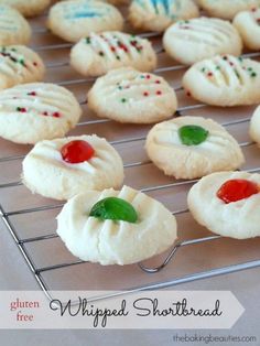 cookies with white frosting and red, green and blue sprinkles are on a cooling rack