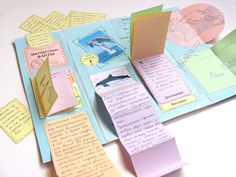 an open book with sticky notes attached to the pages and two dolphins on top of it