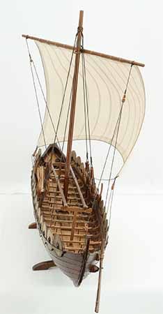 a wooden model of a boat with sails