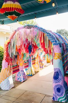 colorful paper lanterns hang from the roof of a covered area in front of a house