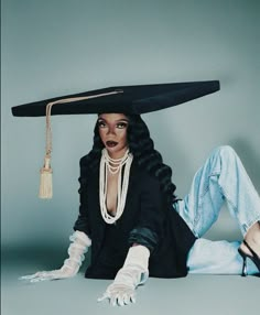 a woman wearing a black hat sitting on the ground