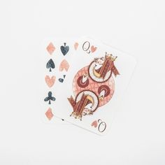 two playing cards sitting next to each other on top of a white surface with hearts and spades