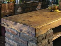 an old wooden table sitting inside of a kitchen next to a brick oven and counter top