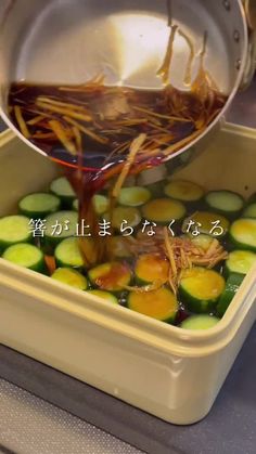 a person pouring sauce on some vegetables in a container