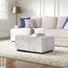 a living room with white furniture and blue pillows