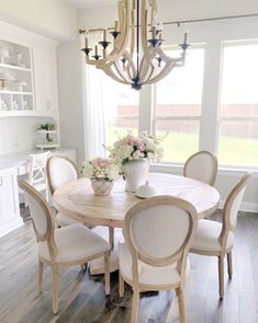 a dining room table with chairs and a chandelier hanging from it's ceiling