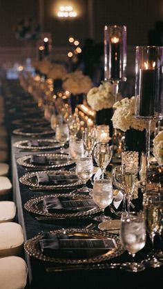 a long table is set with silverware and white flowers