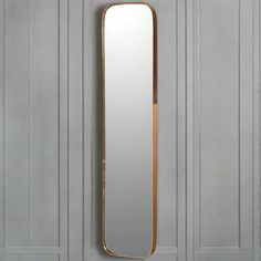 a large mirror mounted to the side of a wall next to a white and gold door