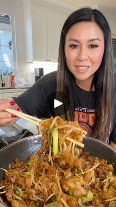 a woman holding chopsticks over a bowl of food