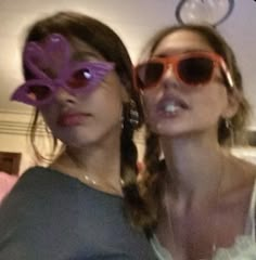 two women wearing sunglasses are posing for the camera