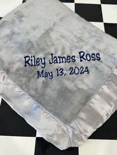 a personalized wedding handkerchief on a black and white checkered tablecloth with the name riley james ross