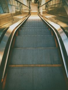 an escalator with two people riding on it