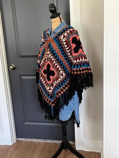 Ready to Ship / Free Shipping I can just see this poncho with jeans and Cowgirl Boots.  I designed this look around the center Black and Terra-cotta motif, because it reminded me of a tooled leather belt and western boots. I love the Black and Light Brown along the bottom edge with the Black Fringe.  The look with this little denim dress proves it can be dressed up as well.  It has a drawstring at the neck with wood beads. One Size Cape For Fall Festival, Fall Festival Cape Poncho, Bohemian Black Poncho For Fall, One Size Cape Poncho For Festival, Casual Cape For Fall Festival, Casual Fall Festival Cape, Hippie Poncho For Fall, Hippie Fall Poncho One Size, Hippie Style Fall Poncho One Size