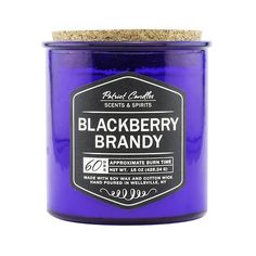 a blue jar with a cork lid and black berry brandy label on the front, against a white background