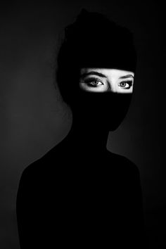 a woman's face is shown with the shadow of her head and eyes behind her