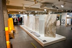 a group of people standing around a room filled with white and brown marbles on display