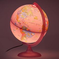 a pink globe on a red stand with a black cord attached to the top and bottom