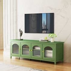 a living room with a green cabinet and white walls, along with a large painting on the wall