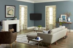 a living room filled with furniture and a flat screen tv mounted on the wall over a fireplace