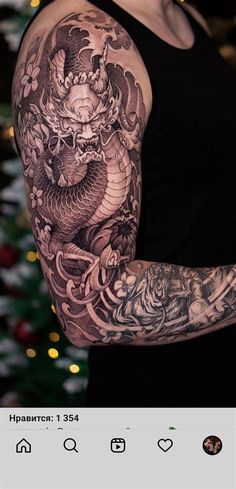 a woman with a dragon tattoo on her arm and shoulder, standing in front of a christmas tree