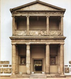 an old building with columns and statues on the outside