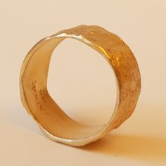 Organic form meets expert craftsmanship with this stunning solid 18K gold women's wedding band. A subtle yet sensational statement, this piece has an apparent weight and impressive width with naturally undulating sides and a rough-textured surface. Each ring is handcrafted and one of kind just like the singular union they represent. ◈ DETAILS Weight: 6g Width: 12-13mm / 0.47''- 0.51'' Thickness: 1.1-1.5mm / 0.39''- 0.06'' ◈ MATERIAL 18K Solid Gold ◈ ALSO AVAILABLE IN 14K Yellow, Rose, or White G Heirloom Engraved Yellow Gold Ring With Hammered Detail, Hammered Jewelry With Round Band For Wedding, Heirloom Hammered Wedding Rings, Heirloom Engraved Hammered Yellow Gold Ring, Heirloom Hammered Wedding Jewelry, Hammered Gold Bands As A Gift, Wedding Jewelry Wide Band Hand Forged, Hammered Round Band Wedding Rings, Hand Forged Yellow Gold Engraved Ring For Anniversary