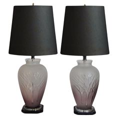 two white vases with black lamps on top of each one and the same shade