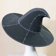 a white mannequin head with a black hat on it's head and stitches all over the top